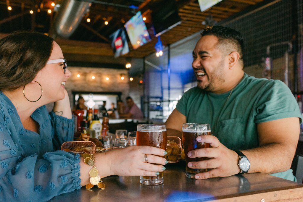2023 08 12 TDC 301Brewery 0011-visit-sebring-fl couple laughing over a meal of burgers, tots, and cold beer at The 301 eatery in Downtown Sebring, FL