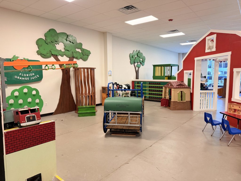 Another portion of the interior showing faux trees against the wall and a mooing cow that is nicknamed Milkshake.