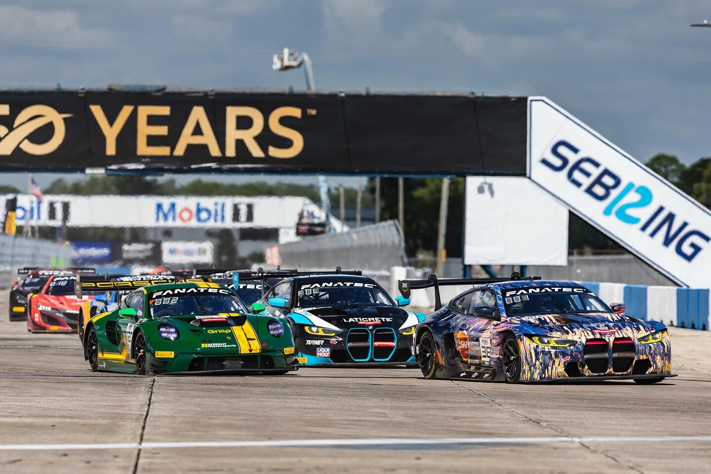 Racecars participating in Fanatec GT World Challenge race down a straight at Sebring International Raceway