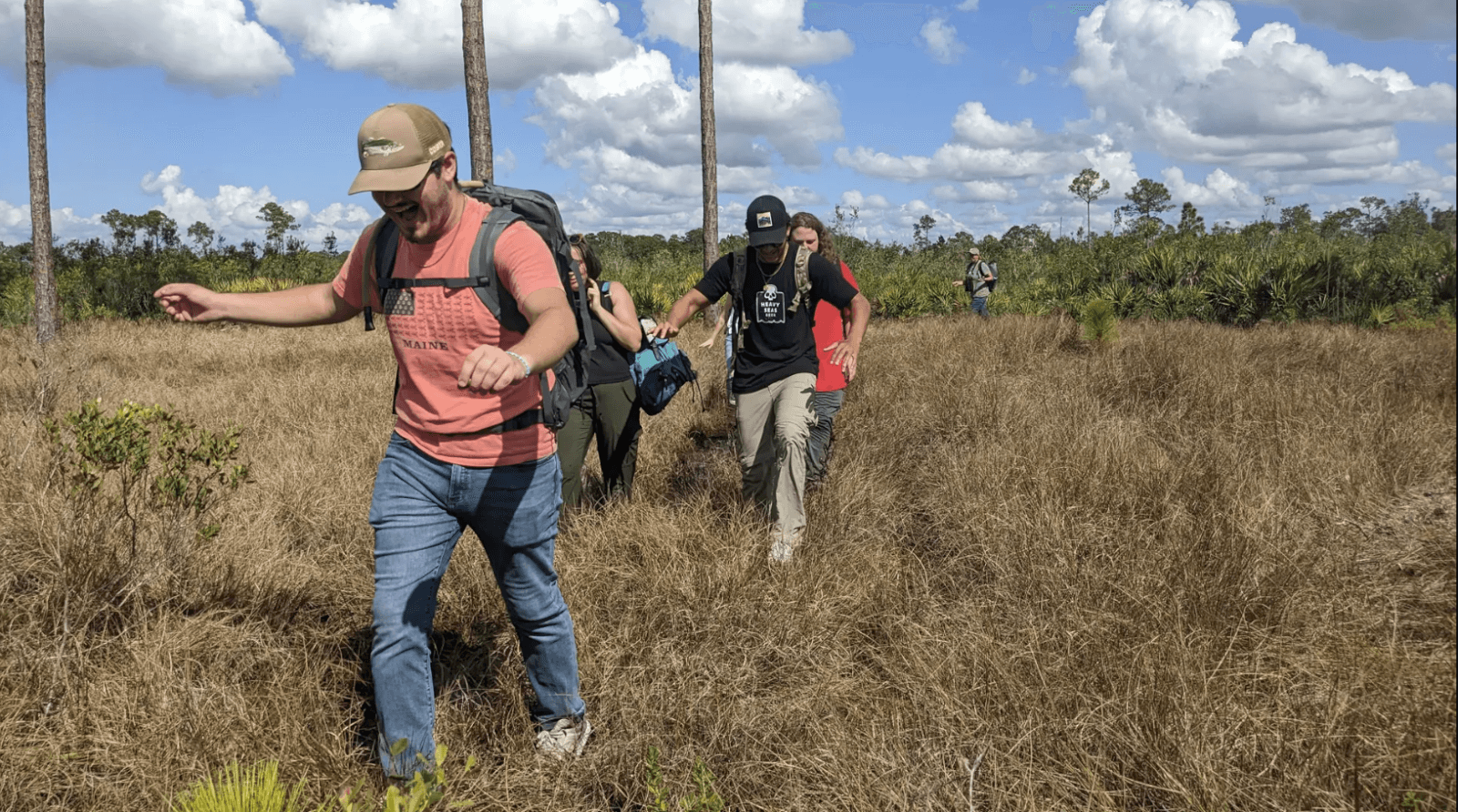 Group of people hiking through the natural Florida scrub forest at Archbold Biological Station in Venus, FL