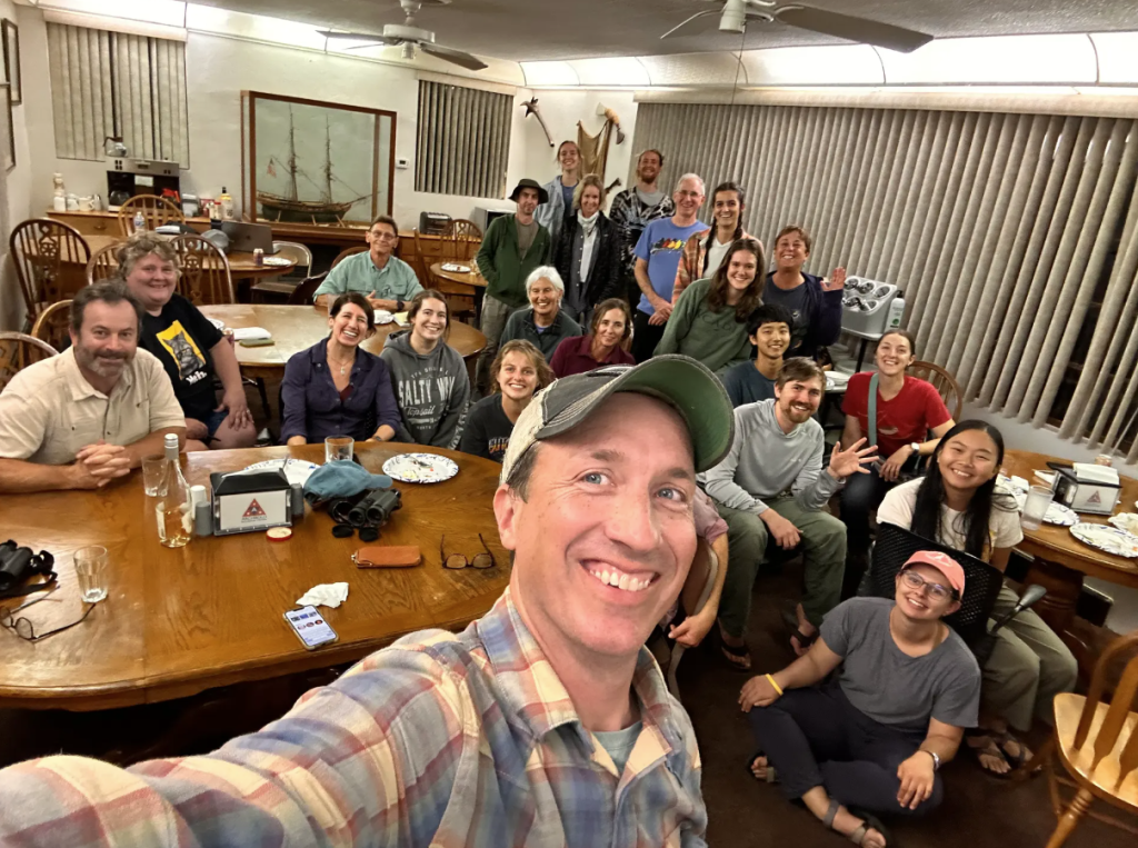 Multi-generational group of explorers gathered around tables in a room at Archbold Biological Station in Lorida, FL preparing to embark on the 26th Annual Lake Placid Christmas Bird Count