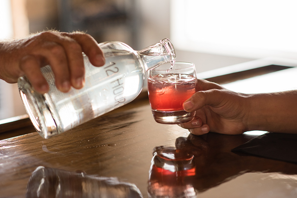 Close up of hand pouring 12 Hour moonshine into a glass at Sugar Sand Distillery