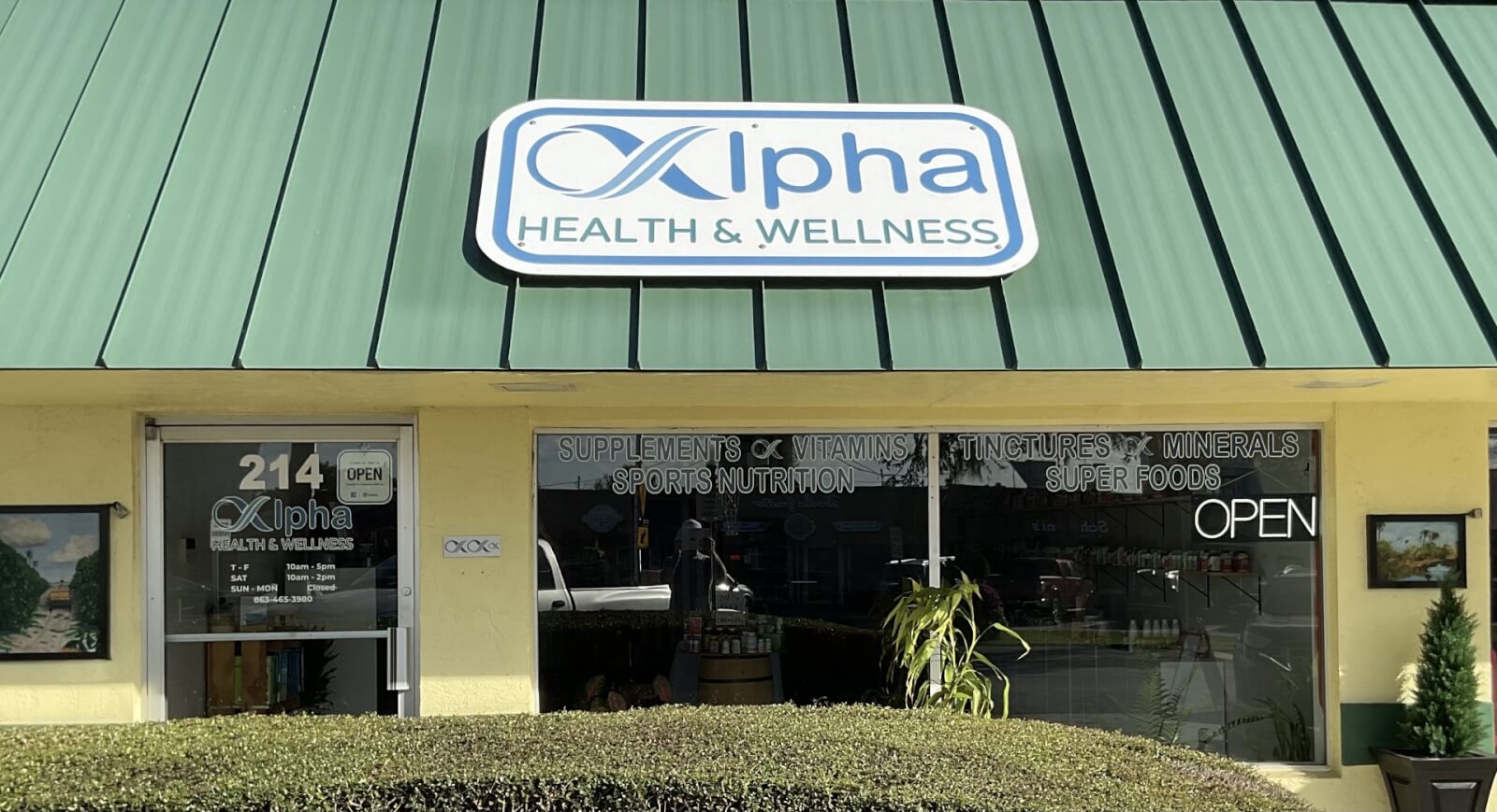 Exterior of a health and wellness store, with big windows showing inside of business and a green roof.