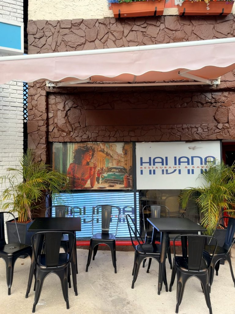 havana-visit-sebring-fl Dark brown stone exterior with light up name display tv, and black metal outside seating