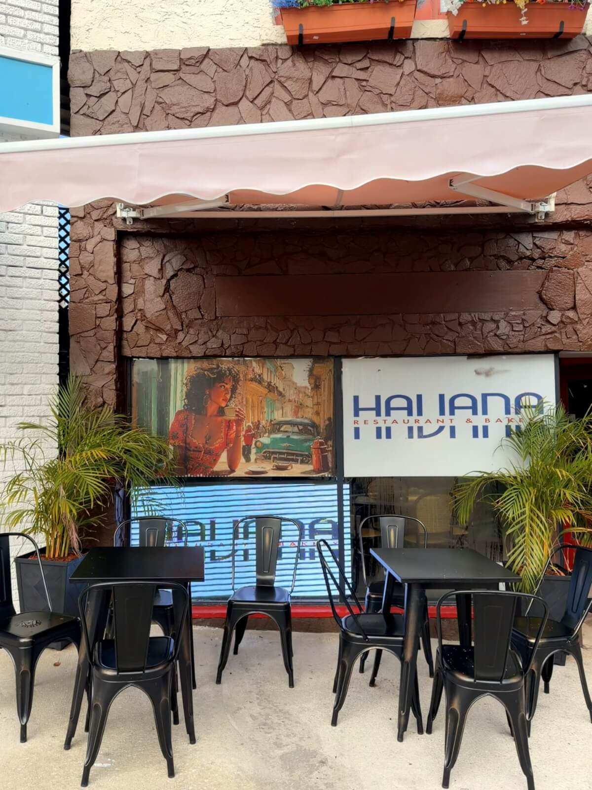 Dark brown stone exterior with light up name display tv, and black metal outside seating