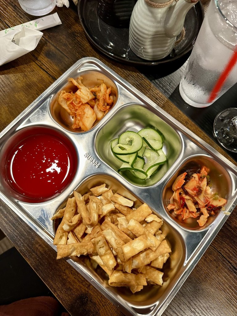 Colorful Jinsoo Kitchen starter plate in Sebring, Florida with pickled vegetables and crispy noodles.