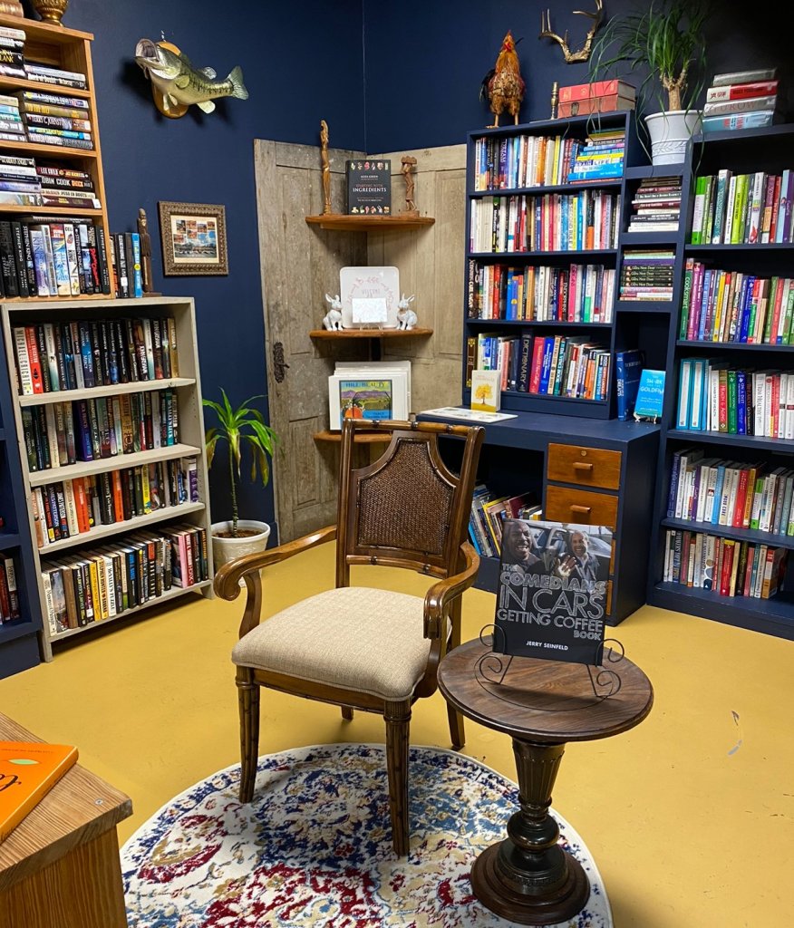 mudd-visit-sebring-fl Bookcases adorn a dark blue wall showcasing a variety of books.