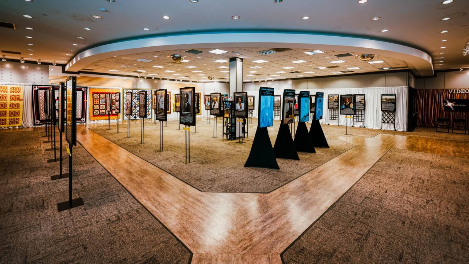small aahm-visit-sebring-fl Showroom display in Sebring, Florida celebrating historical contributions, with a walkway featuring portraits and artwork.